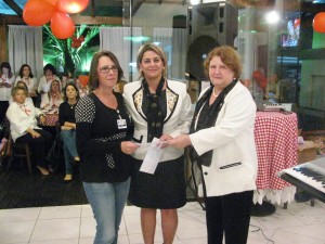 Representantes da Casa da Amizade entregando o comprovante das doações para a gerente geral do Hospital Santo Antônio, enfermeira Izabel Casarin.